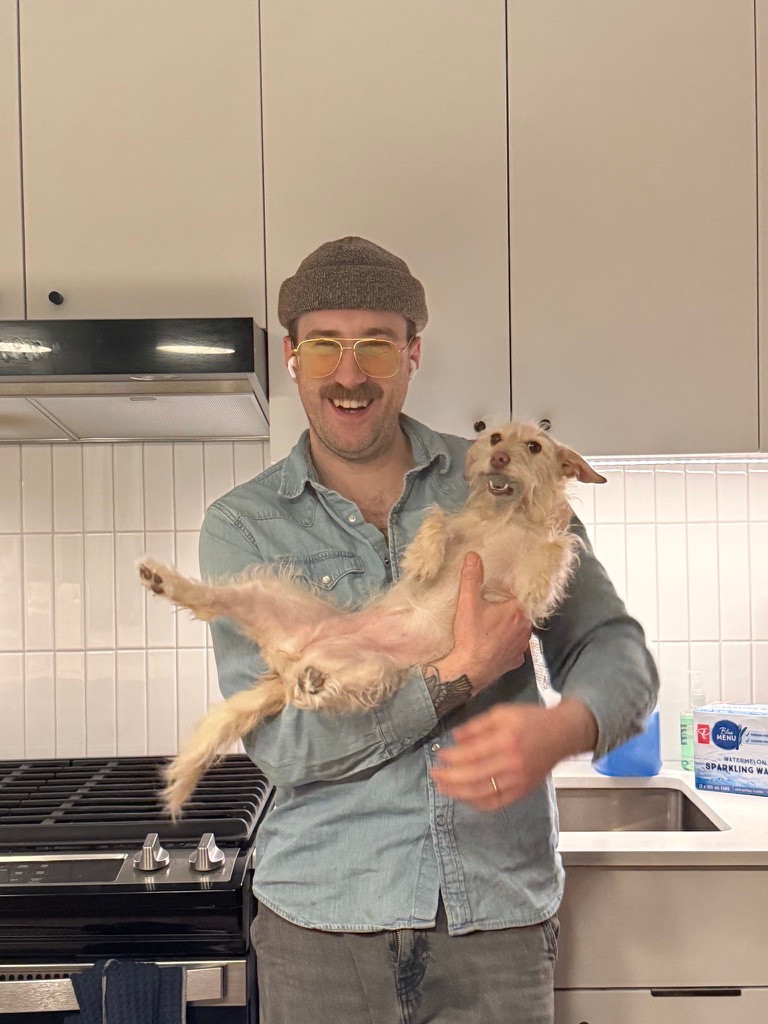 Jesse smiling while holding his dog